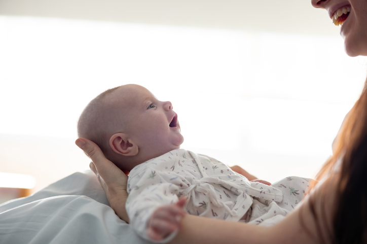 Beautiful newborn baby looking at his mother at the hospital