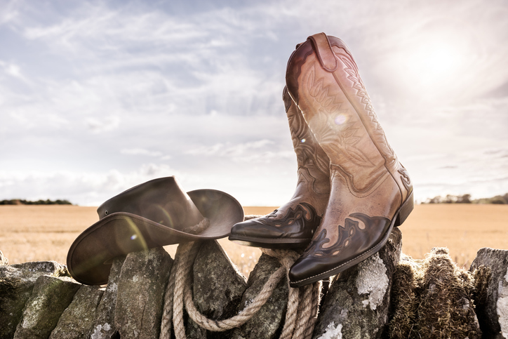 Cowboy hat and boots at ranch stables, country music festival live concert or line dancing concept